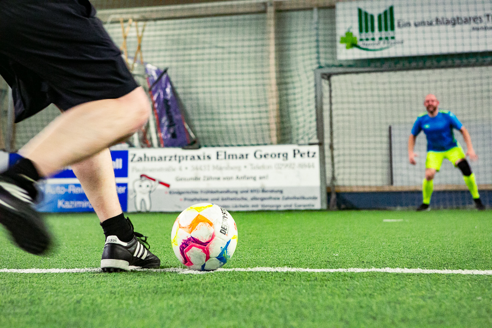 Mann steht im Fußballtor und ist bereit den Ball zu fangen.