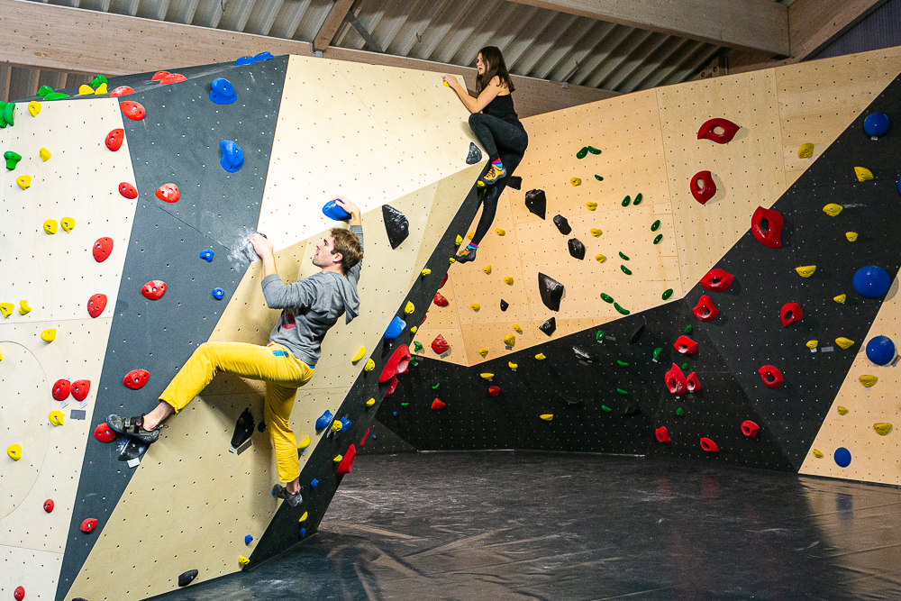 Zwei Personen kletern die überhängende Seite an dem Kletterdome in Marsberg